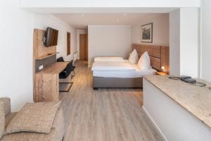 ein Hotelzimmer mit einem Bett und einem Schreibtisch in der Unterkunft Bierenbacher Hof in Nümbrecht