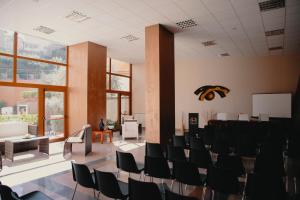 uma sala de conferências com cadeiras pretas e um pódio em Halykos Hotel em Cammarata