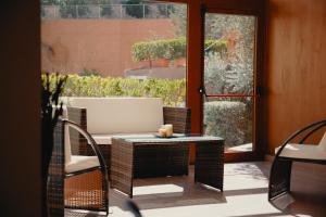 a patio with a table and chairs and a window at Halykos Hotel in Cammarata