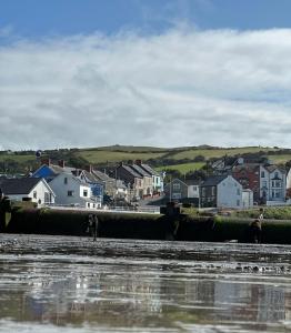 a group of people walking on the beach with houses at Powys 37 in Borth
