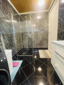 a bathroom with a shower with a black tiled floor at Vadlåsveien 4 in Egersund