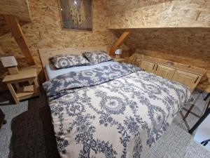 a bedroom with a bed with a blue and white comforter at Vineyard cottage Vinska grajska kašča in Mirna