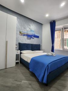 a bedroom with a large bed with a blue blanket at Gradini Partenopei in Naples