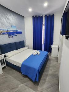 Schlafzimmer mit einem großen Bett und blauen Vorhängen in der Unterkunft Gradini Partenopei in Neapel