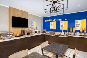 a breakfast room with a table and a tv at Days Inn by Wyndham Edmundston in Edmundston