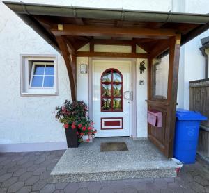 einer Haustür eines Hauses mit Topfpflanze in der Unterkunft Bodos-Auszeit in Weitnau