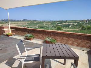 a wooden table and two chairs and an umbrella at Da Elvira in Costigliole dʼAsti