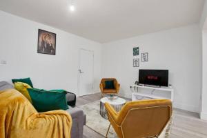 a living room with a couch and a tv at The Stunning Central Rugby Gem - Sleeps 10 in Rugby