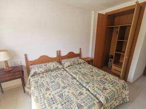 um quarto com uma cama com uma colcha em Apartamento Llançà, 2 dormitorios, 5 personas - ES-89-119 em Llançà