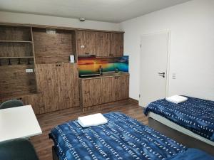 ein Hotelzimmer mit 2 Betten und einem TV in der Unterkunft Heidenheimer Zimmer in Heidenheim