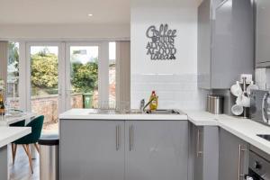 a white kitchen with a sink and a window at The Stunning Central Rugby Gem - Sleeps 10 in Rugby