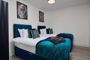 a bedroom with a large bed with blue and white sheets at The Stunning Central Rugby Gem - Sleeps 10 in Rugby