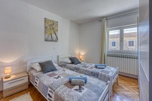 a bedroom with two beds and a window at Pool House Lilly - Happy Rentals in Višnjan +29 photos