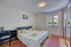 a bedroom with a bed and a desk and windows at Pool House Lilly - Happy Rentals in Višnjan