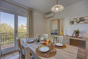 a dining room with a table and a balcony at Pool House Lilly - Happy Rentals in Višnjan
