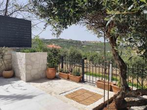 a fence with potted plants and a tree at Hammam, Private Pool & Home Cinema - Green Sight in Prasás