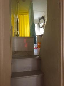 Baño con una escalera que conduce a un espejo amarillo en Kant, en Berlín