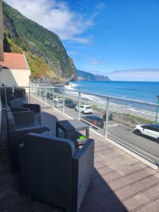 Un balcón con sillas y vistas al océano. en Ocean Breeze Apartment, en São Vicente