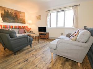 a living room with two chairs and a couch and a television at Pirata in St Austell