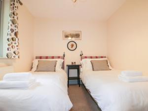 圣奥斯特尔Pirata的墙上挂钟的房间里设有两张单人床