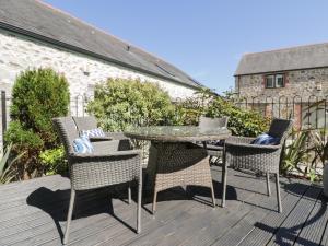 a patio with a table and chairs on a deck at Pirata in St Austell