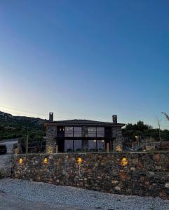 a house on top of a stone wall at Modern Stone Villas with Swimming Pool in Aliveri