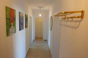 a hallway with paintings on the walls of a room at Stilvolles Design Apartment mit Rheinblick inkl Netflix & Parkplatz in Düsseldorf