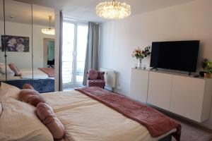 a bedroom with a large bed with a flat screen tv at Stilvolles Design Apartment mit Rheinblick inkl Netflix & Parkplatz in Düsseldorf