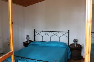 a bedroom with a bed with a blue bedspread at Lo Chalet della antica Locomotiva in Camigliatello Silano