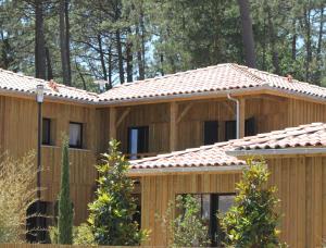 a wooden house with a tiled roof at Domaine du Ferret Restaurant & Spa in Cap-Ferret