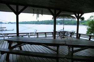 eine Holzterrasse mit einem Tisch, Stühlen und einem Sonnenschirm in der Unterkunft Captains Cabin - Cozy Cabin in Laurel Island in East Hampton