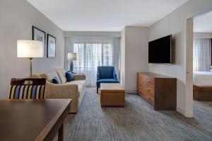 a hotel room with a couch and a bed at Embassy Suites by Hilton Detroit Metro Airport in Romulus
