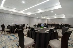 a conference room with tables and chairs with people in it at Embassy Suites by Hilton Detroit Metro Airport in Romulus +34 photos