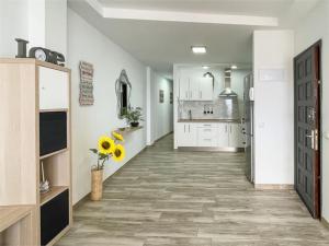 uma grande cozinha com paredes brancas e um corredor com piso em Beachfront Apartment incl highspeed WIFI em Melenara