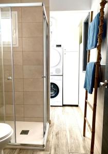 uma casa de banho com uma máquina de lavar roupa e uma máquina de lavar e secar roupa em Beachfront Apartment incl highspeed WIFI em Melenara