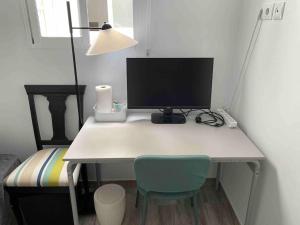 uma secretária com um monitor de computador e uma cadeira em Beachfront Apartment incl highspeed WIFI em Melenara