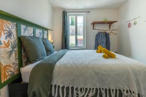 a bedroom with a bed with a teddy bear on it at La maisonnette bien-être in Bagneux