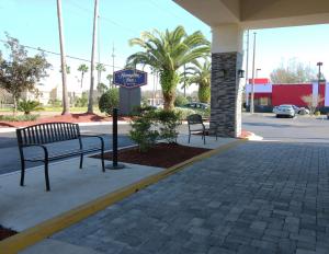 two benches on a sidewalk in front of a gas station at Hampton Inn Saint Augustine-I-95 in St. Augustine