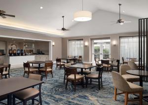 a dining room with tables and chairs and windows at Homewood Suites by Hilton Somerset in Somerset