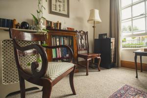 een woonkamer met een stoel en een boekenplank bij Pass the Keys Historic House with Cathedral Views in Lincoln