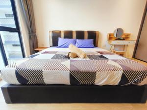 a bedroom with a large bed with blue pillows at Armadale Galacity Minimalist 3 Bedrooms Entire Apartment in Kuching