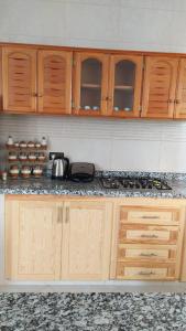 a kitchen with wooden cabinets and a counter top at Appartement proche de la corniche in Al Hoceïma