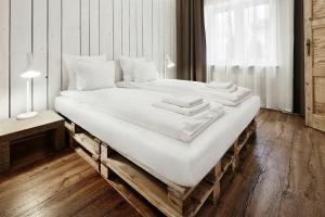 a large bed with white sheets and pillows on it at CityNest Apartments in Krakow