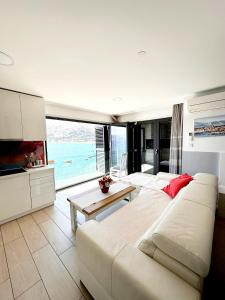 a living room with a white couch and a large window at Apartments Palada 1 in Baška