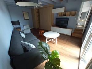 een woonkamer met een bank en een tafel bij Brennick, Maison 4 pers proche mer et plage in Clohars-Carnoët