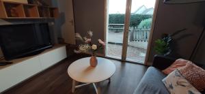 una sala de estar con un jarrón de flores sobre una mesa en Brennick, Maison 4 pers proche mer et plage en Clohars-Carnoët