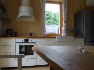 a kitchen with a table and a large window at Willa Potoczówka in Rzyki