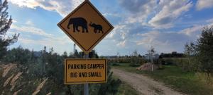 Ein Schild auf einer Straße, auf der steht, Kamele groß und klein zu spielen. in der Unterkunft Vigio Brasta camping in Elektrėnai