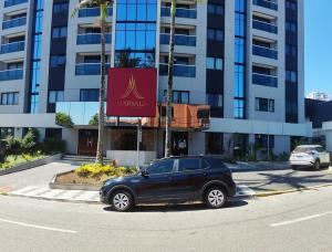 a black car parked in front of a building at Apart Hotel 48 in Mogi das Cruzes