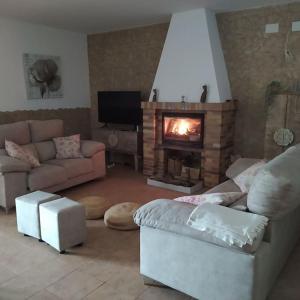 a living room with a couch and a fireplace at Casa Rural La Costa in La Lapa